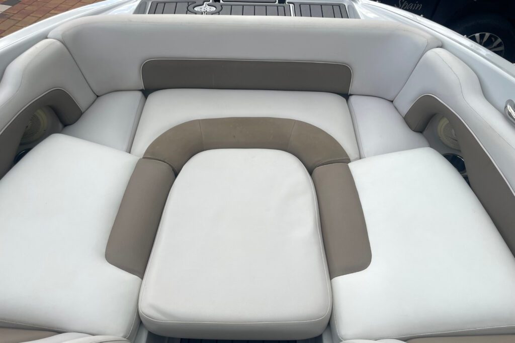 Solarium de proa del barco E2XS con tapicería blanca y gris, asientos en U y altavoces integrados a bordo